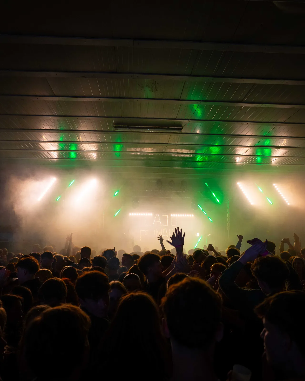 Halle hell erleuchtet mit Crowd im Vordergrund und Bühne im Hintergrund.