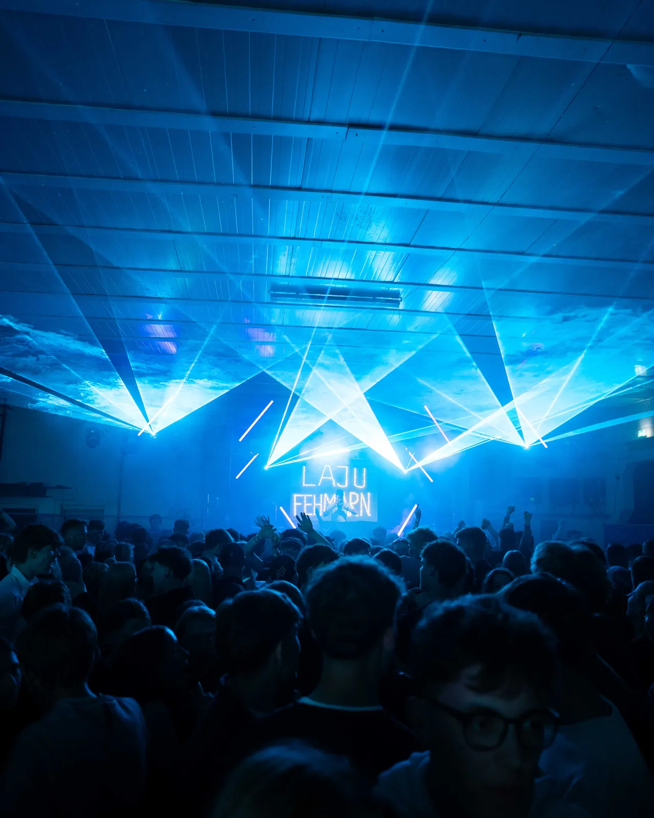 Blaues Licht und hellblaue Laser erleuchten die Halle.