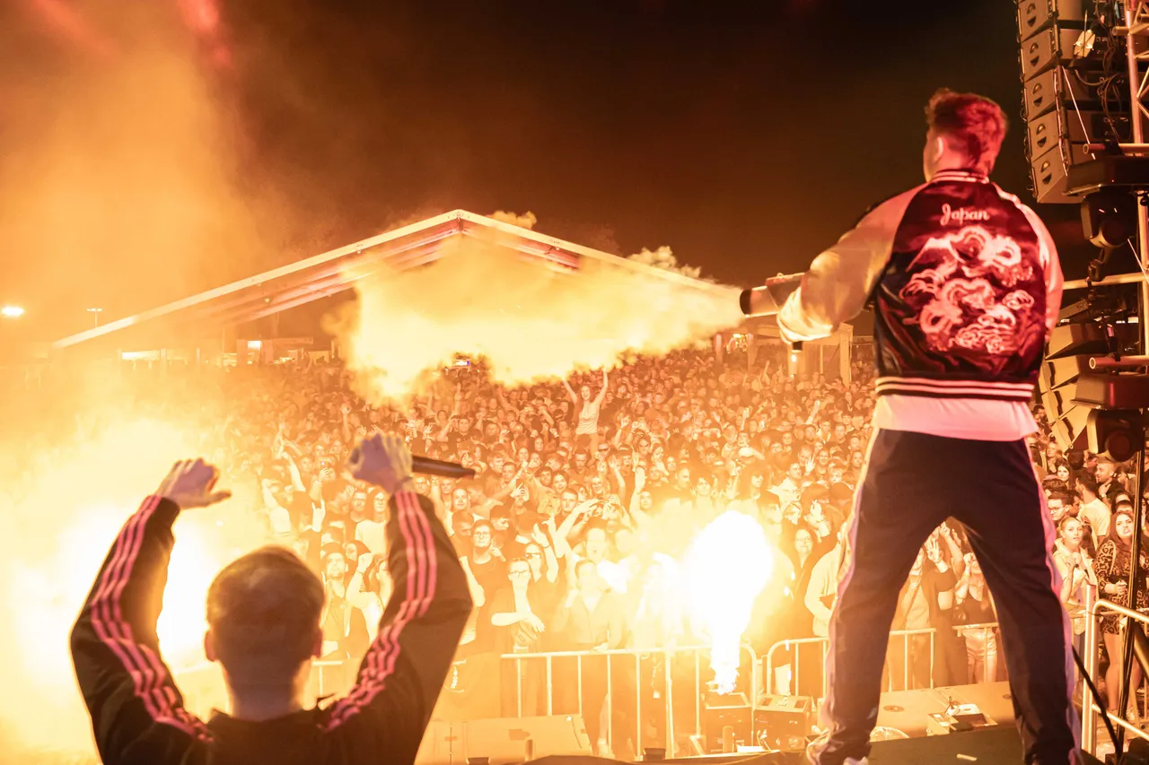 AMXO stehen auf der Bühne mit CO2 Gun und Feuereffekt schießt Flammen. Nr. 3