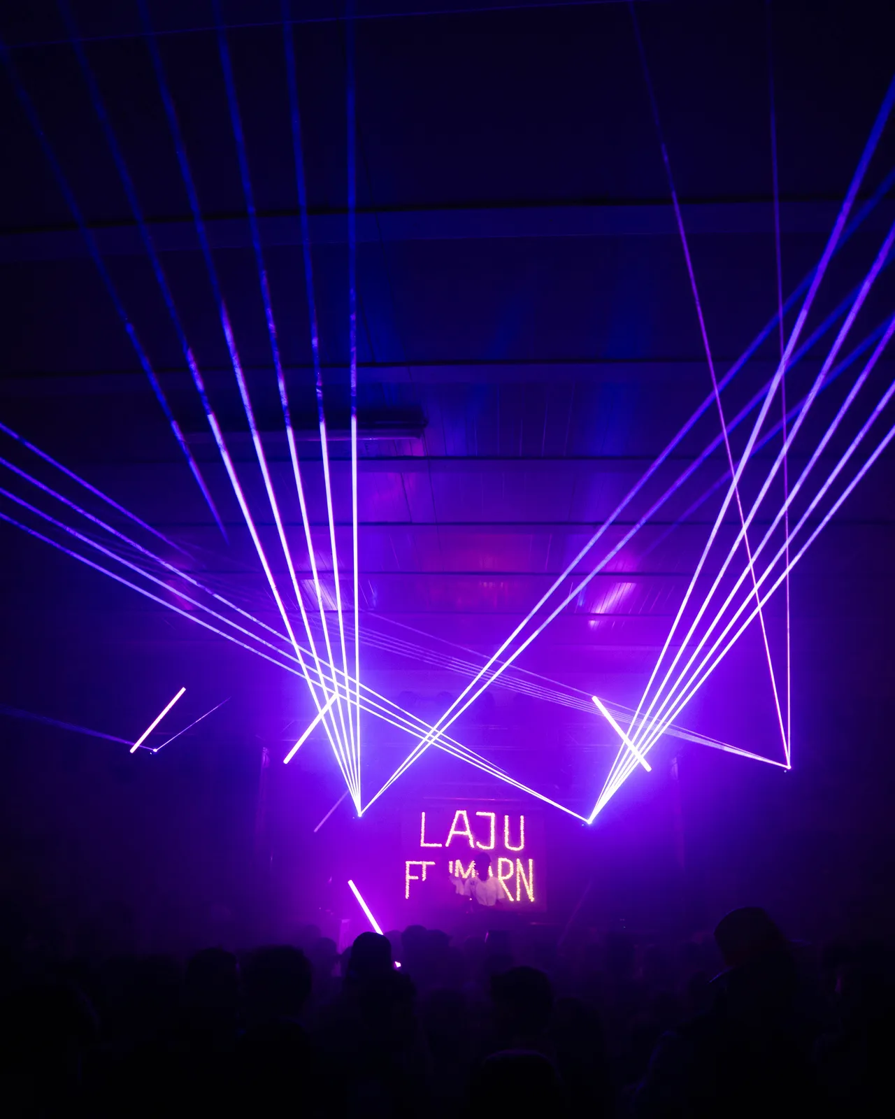 Auf Bühne blickend mit lila Laserstrahlen.