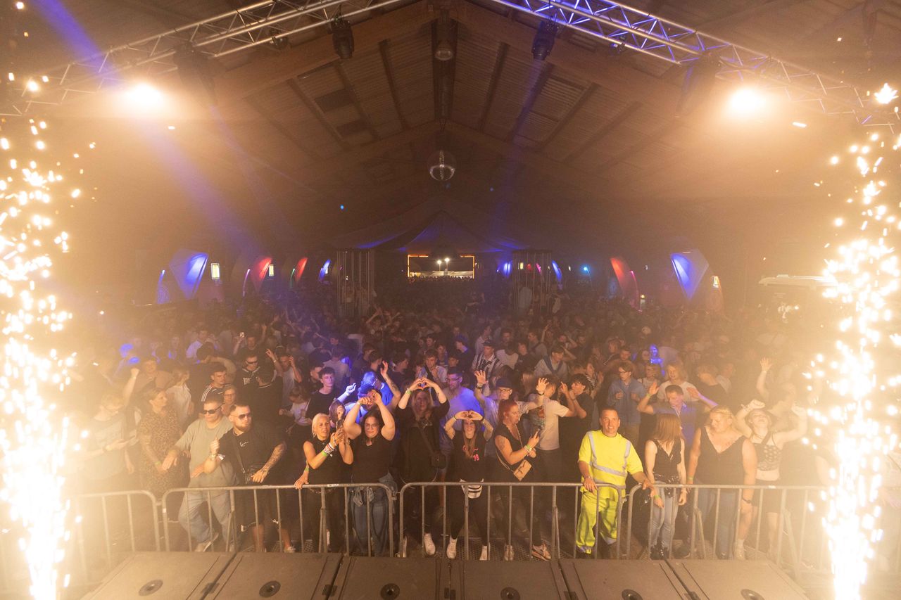 Crowd in Scheune mit Händen hoch