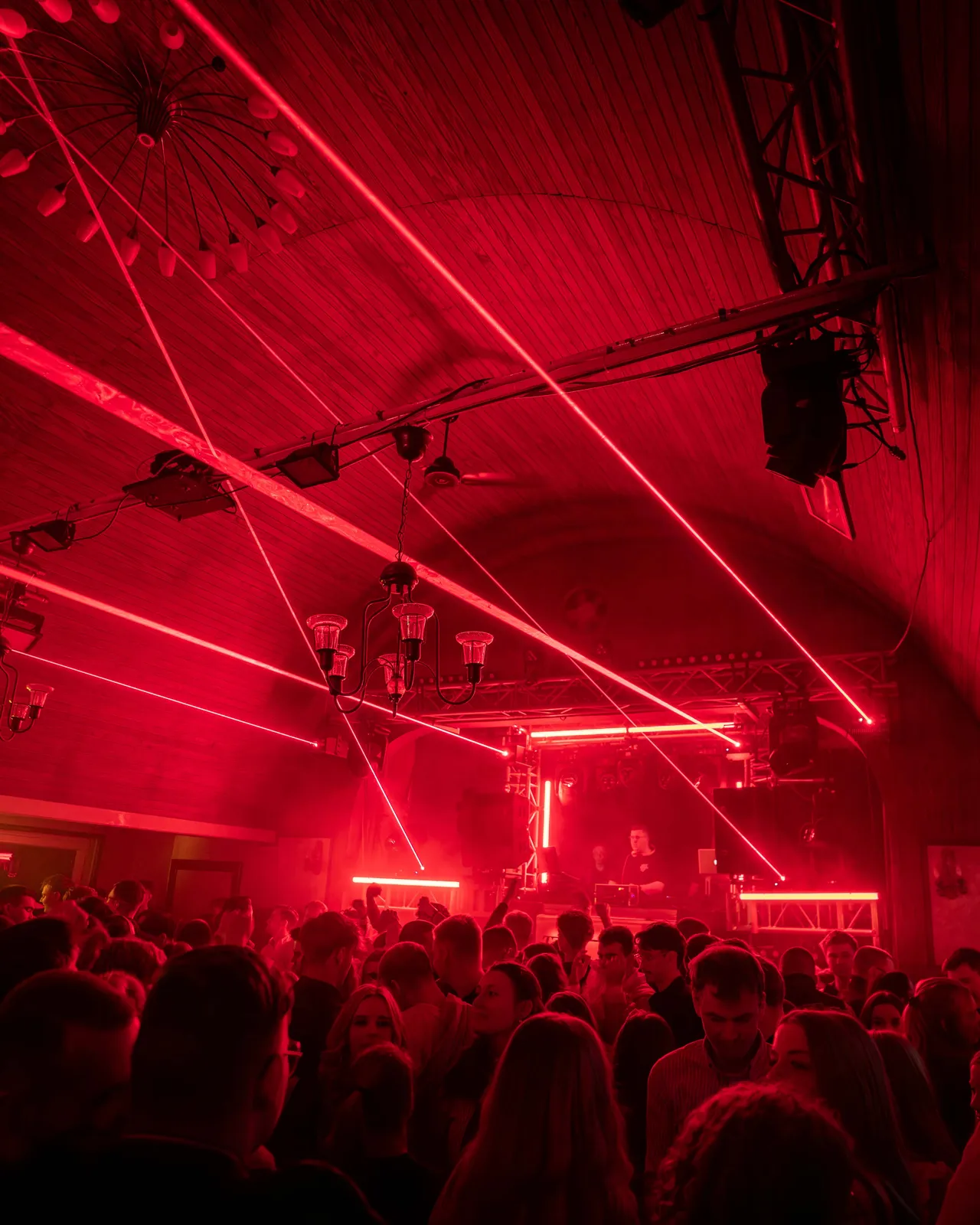 Rotes Licht und rote Laser von der Bühne kommen über Crowd hinweg.