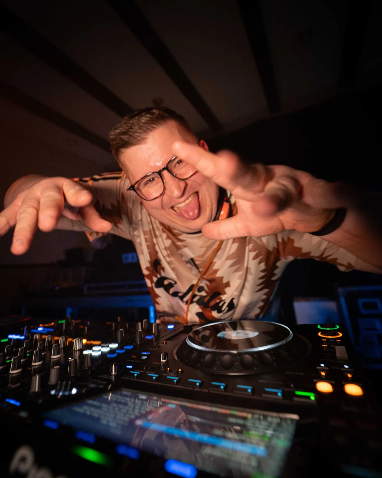 Nahaufnahme von Daniel Mic am DJ Pult, während er posiert.